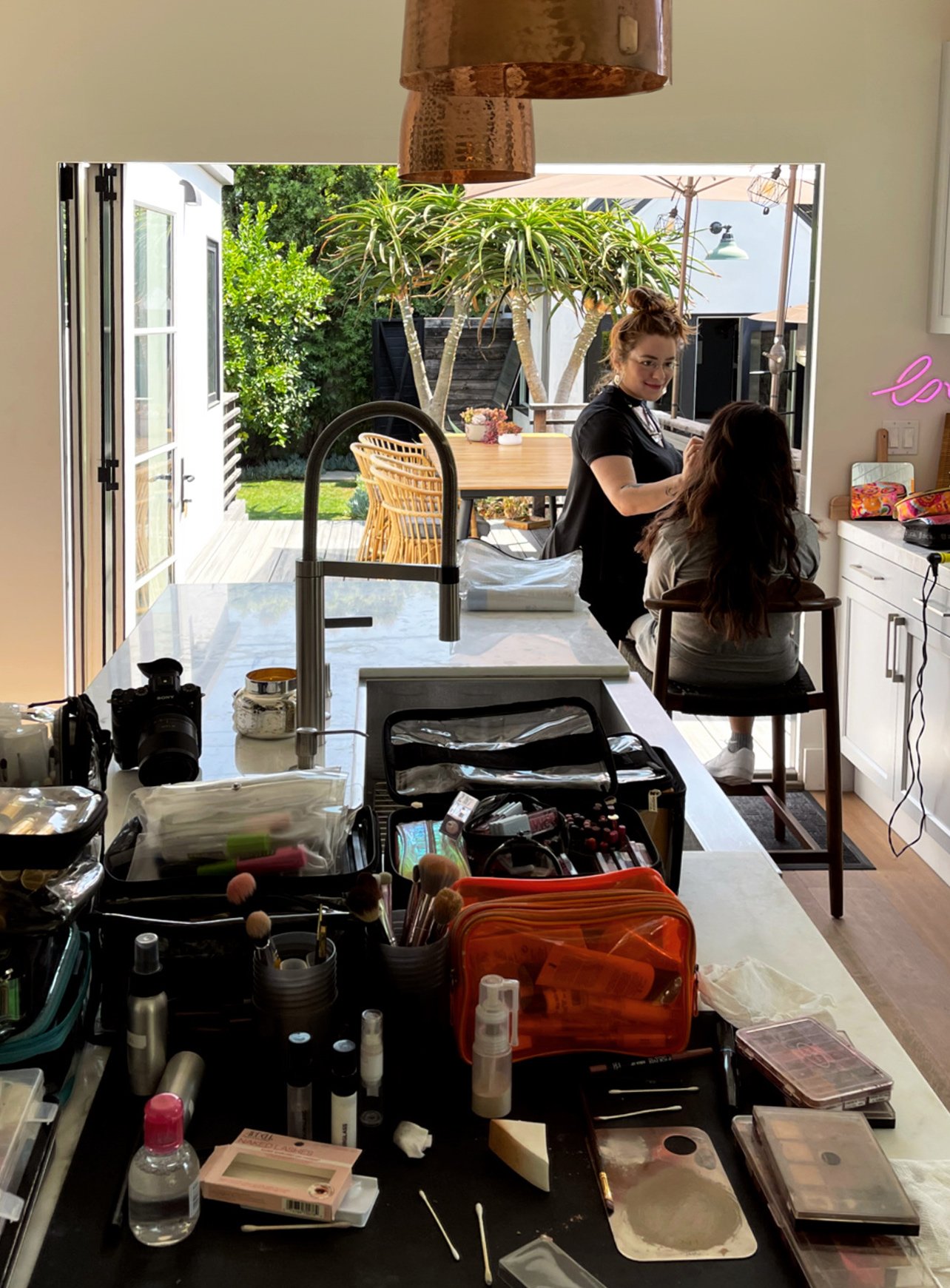 Makeup artist working on a client at the kitchen counter at the LA Boudoir Bungalow